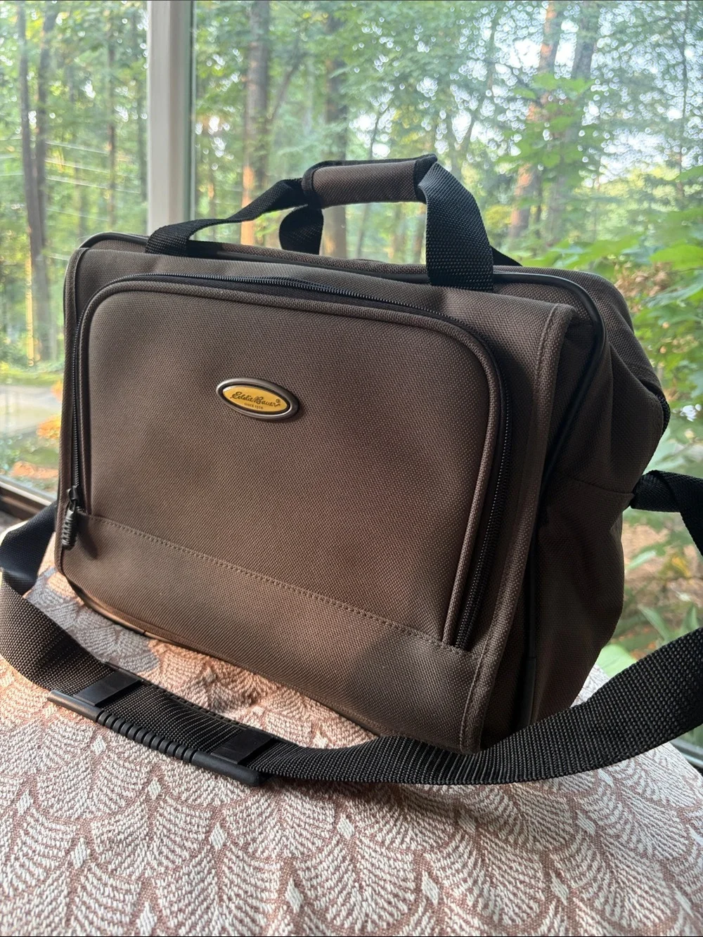 Eddie Bauer army green carry-on bag with black hand straps and shoulder strap